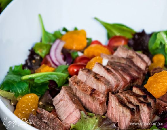 Для заправки смешаем оливковое масло, жидкость от мандаринов, соль и перец.
Смешаем заправку с салатом, приготовленным заранее, а сверху красиво выложим тёплое мясо.
Красиво и вкусно. Приятного аппетита!