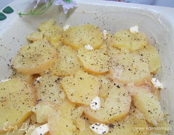 Форму для запекания обильно смазать сливочным маслом. Выложить в форму картофель. Посолить, поперчить и добавить немного сливочного масла.