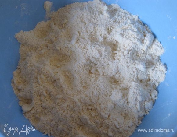 Муку просеять, всыпать разрыхлитель, 1/2 чайной ложки соли. Добавить маргарин, нарезанный кубиками. Растереть маргарин с мукой руками в крошку.