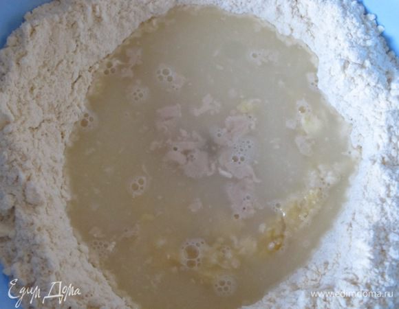 В теплую сыворотку добавить сахар и свежие дрожжи, можно использовать и сухие дрожжи. Оставить на 15 минут, чтобы поднялась пена. Вылить в муку, вбить 2 яйца.