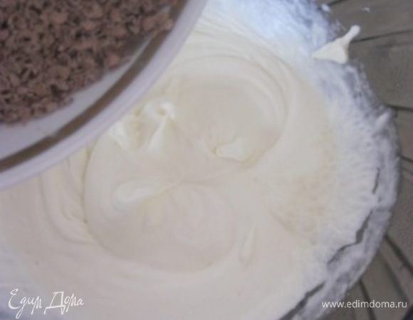 К взбитым сливкам добавить тертый шоколад.
Аккуратно перемешать.
