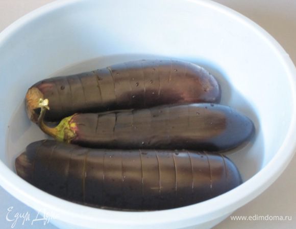 Положить баклажаны в соленую воду на 1,5 часа, чтобы ушла горечь.