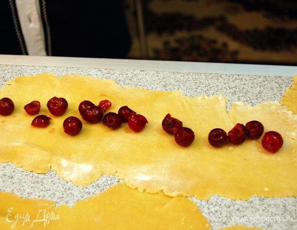 Каждый шарик раскатываем в прямоугольник и сверху выкладываем вишню.