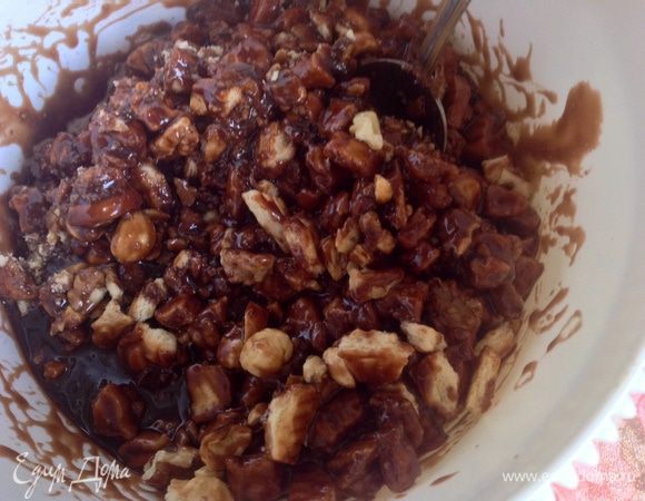 Добавить в образовавшуюся смесь яйцо и ванильный сахар, тщательно размешать. Перелить шоколадную массу в миску с печеньем. Перемешать. Добавить орехи и снова перемешать. 