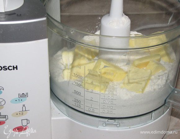 Просеять муку со щепоткой соли. Сливочное масло нарезать небольшими кусочками и порубить ножом вместе с мукой. Я это делаю в кухонном комбайне.