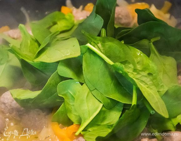 Кстати, не забываем о нашим макаронах - они ведь уже готовы.
В сковородку добавляем четверть стакана кипятка, перемешиваем и доводим до кипения. И сразу высыпаем сюда шпинат 