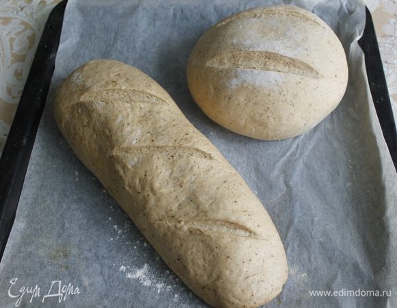 Заранее нагреть духовку до температуры 250 гр. Поставить в нее огнеупорную миску с кипящей водой. Смазать  заготовки молоком, сделать надрезы и выпекать в духовке  20 минут. Затем уменьшить температуру духовки до 200 С  и продолжать выпекать хлеб еще 30 минут. 