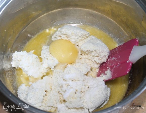 Растапливаем 50 г сливочного  масла, добавляем  отжатый творог, соль, соду и яйцо и быстро и тщательно смешиваем до однородности. 