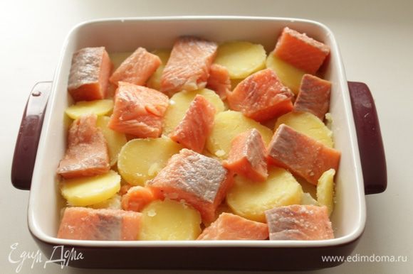 Картофель варить 15 минут, нарезать кружочками, выложеить на противень. Филе рыбы нарезать крупными кусочками, выложить на картофель.