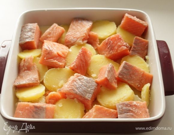 Картофель варить 15 минут, нарезать кружочками, выложеить на противень. Филе рыбы нарезать крупными кусочками, выложить на картофель.