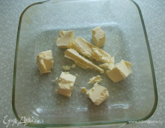 Разогреваем духовку до 200 градусов. Режем сливочное масло кубиками и выкладываем в форму. 