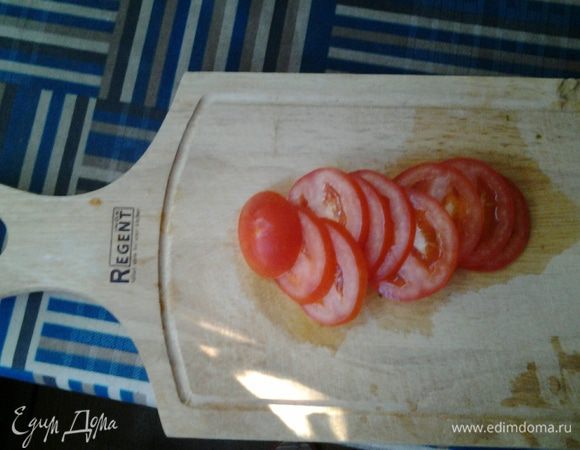 Пока омлет запекается, режем помидор тонкими колечками.