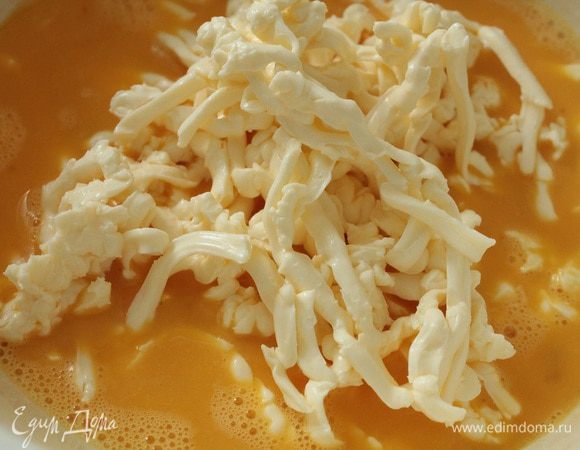 Яйца слегка взбить с помощью вилки, сырки натереть на крупной терке, перемешать.