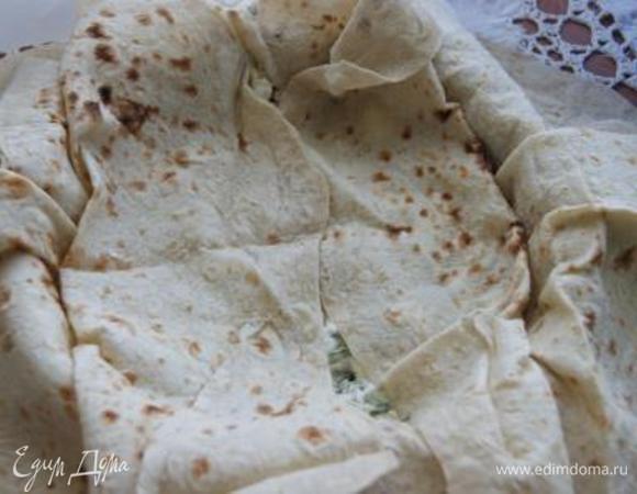 На дно формы с лавашами выложить 1/3 начинки, смазать заливкой, 2 конца верхнего лаваша завернуть внутрь, смазать заливкой.