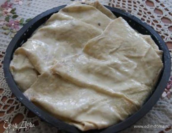 Выложить вторую треть начинки, повторить манипуляцию, то же самое с оставшейся частью начинки и последним нижним лавашом. Смазать пирог оставшейся заливкой.