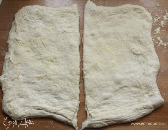 Рабочий стол подпылить горстью кукурузной муки. Вывалить на стол из миски тесто, сформировать руками четырёхугольник. С помощью скребка разделить тесто пополам.