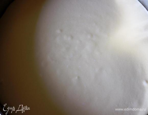 Вылить сырную массу на основу и отправить чизкейк в духовку. В небольшой противень налить кипяток и поставить на дно духовки. Выпекать 15 минут. Затем уменьшить температуру до 120 градусов и выпекать еще 45 минут.
