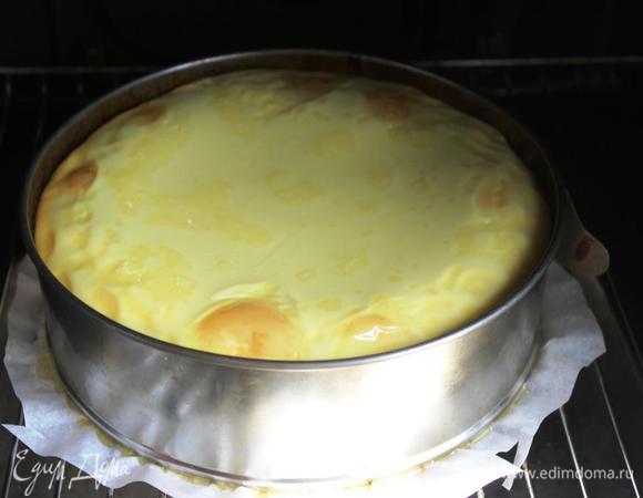 Выпекать при 150 градусов около 60 минут, пока крем не схватится (бока схватятся, а центр останется «дрожать»). 
Во время выпекания слой крема немного поднимется, но при остывании осядет.
Дать чизкейку постоять в духовке до остывания. 