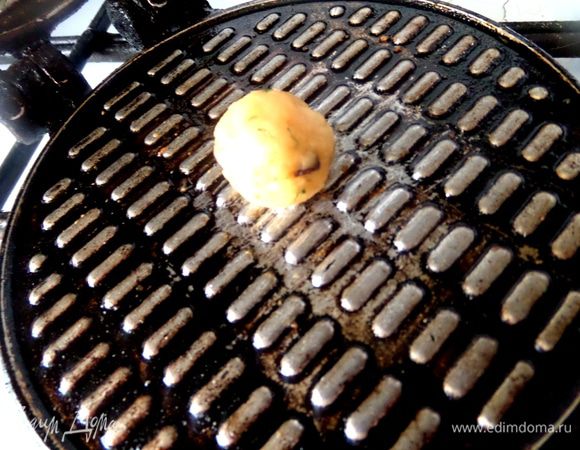 Теперь ставим вафельницу на огонь и разогреваем её с обеих сторон. Затем смажем кисточкой поверхности и кладём шарик в центр.