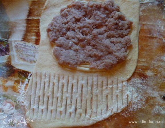 У меня был готовый котлетный фарш с луком и солью. Я добавила к нему воды, перемешала, чтобы фарш стал мокрый, как на чебуреки.
На одну часть теста выложить фарш, вторую часть прошла роликом для теста.