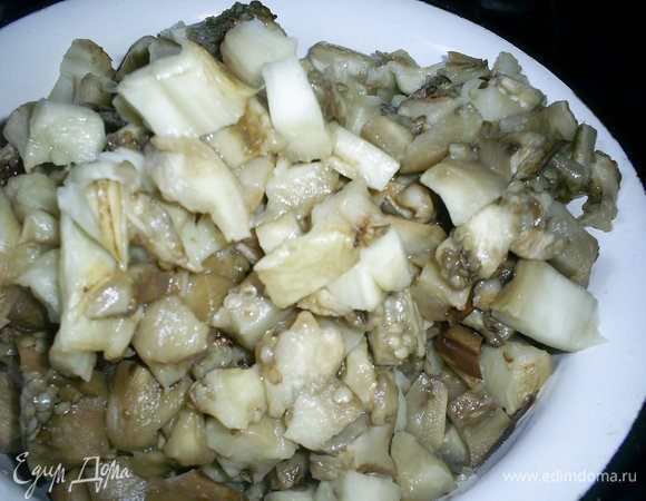 Займемся начинкой. Баклажаны (у меня 2 средних) помыть, разрезать вдоль на половинки, срезы смазать растительным маслом и запечь до мягкости в разогретой духовке при 200 градусах 20-30 минут. С остывших баклажанов снять кожицу (это сделать совсем легко), порезать их кубиками.