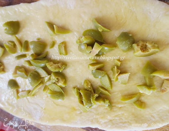 Для другого вида булочек, разрезаем  оливки на небольшие кусочки. Лепешку смазываем маслом и выкладываем оливки. 