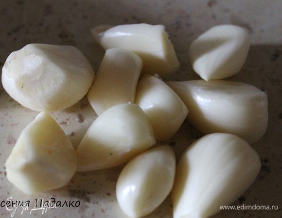 Чеснок очистить и разрезать на половинки.