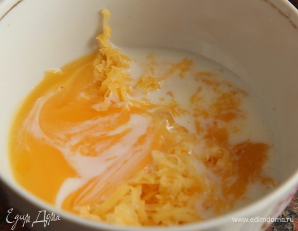 Добавляем соус к томатам и еще раз пробиваем погружным блендером. Ставим кастрюлю на небольшой огонь, доводим до кипения. Яичный желток взбиваем с натертым сыром и 2 столовыми ложками сливок.