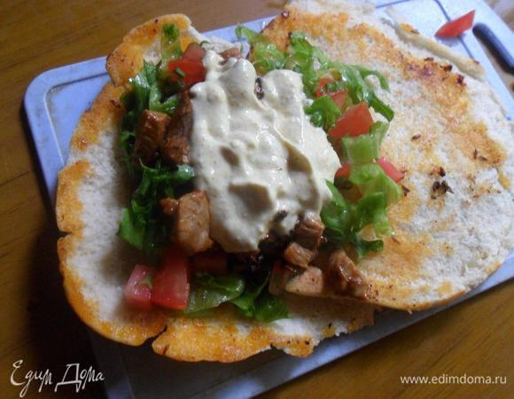 На второй скорвороде с маслом разогреть питу.
На питу выложить салат, мясо, полить соусом. До краёв не доходить примерно на 2 см.