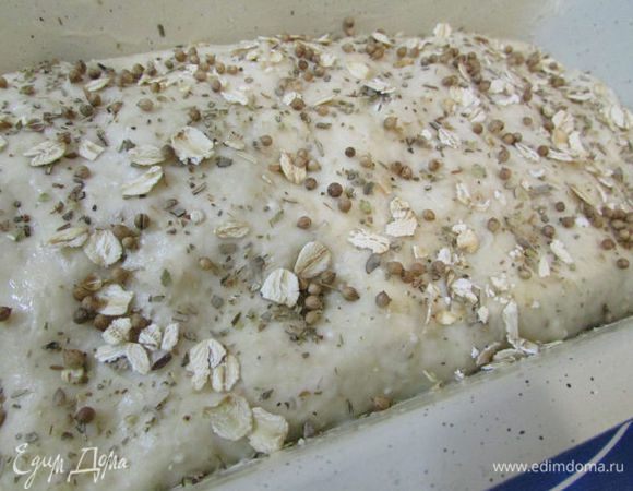 Разогрейте духовку до 190 градусов. Сбрызните хлеб водой и посыпьте сухими травками и овсяными хлопьями (это по желанию). Поставьте в духовку. Выпекайте 40 минут. Готовность проверяйте лучинкой, она должна выходить из буханки сухой.