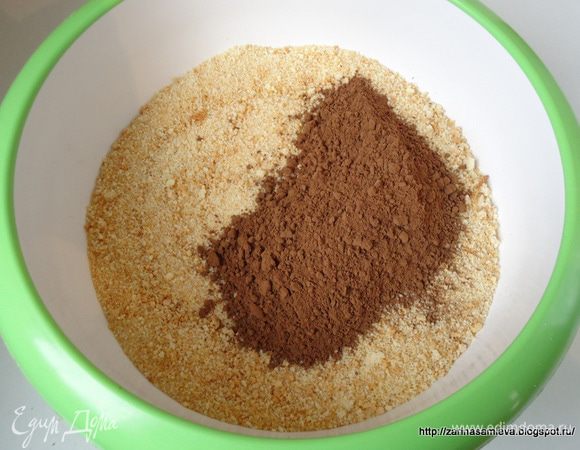 Для удобства приготовления шоколадной массы,  бисквитную крошку высыпать в глубокую миску. Туда же всыпать какао и все хорошо перемешать до объединения.