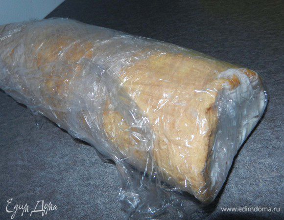 Развернуть полученный корж и смазать кремом, не доходя до краев. Свернуть корж снова, прижимая края. Накрыть пленкой и поместить в холодильник в течение 6 часов.