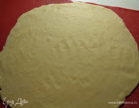 Через полчаса достаем тесто из холодильника и раскатываем его на силиконовом коврике (или пекарской бумаге) в круг, диаметром 26 сантиметров.