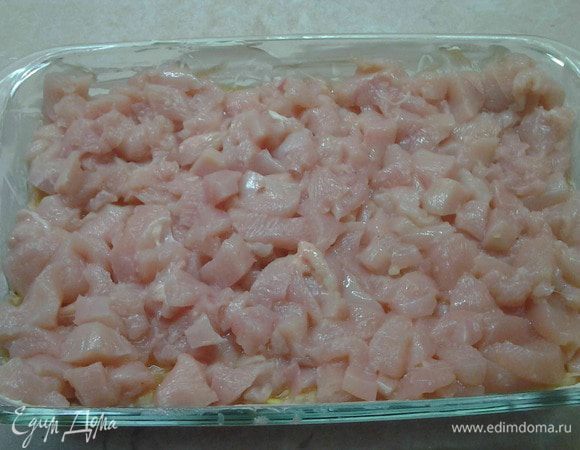 Куриную грудку порезать на мелкие кусочки. Выложить ее сверху картофельно-кабачковой смеси. Немного посолить.
