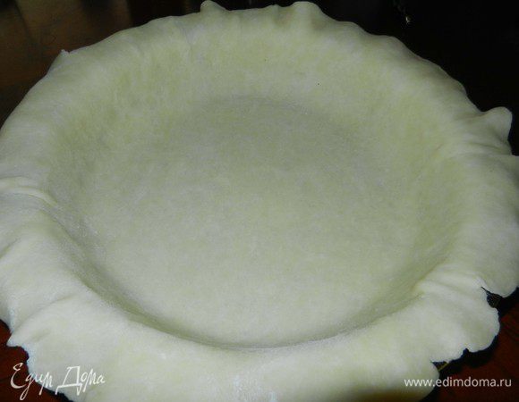 Достать тесто из холодильника. Первую половинку раскатать на посыпанной мукой рабочей поверхности и разместить на смазанную маслом форму для пирога.