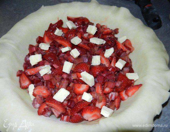 Дно форму посыпать 2 ст.л. сахара, потом засыпать начинкой. Сверху полить 1 ст.л. лимонного сока и выложить мелко нарезанные кусочки холодного масла (30г).  Края теста смазать молоком или сливками.