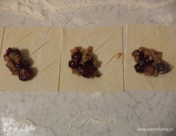 На одну половину выложить начинку, на другой сделать поперечные надрезы с промежутком около 1 см, не доходя до края 1,5 см.
Накрыть начинку половинкой теста с надрезами, края защипать.