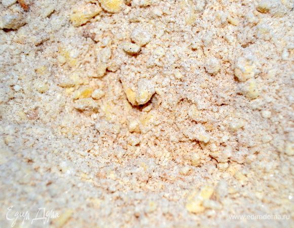 Просеять муку, масло натереть на крупной терке, добавить 100 г сахара, соль, корицу и разрыхлитель. Перемешать до образования равномерной крошки.