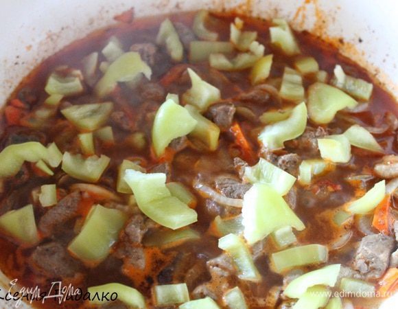 Томатную пасту развести в воде и добавить к мясу. Тушить под крышкой 20 минут. Затем кладем болгарский перец, нарезанный крупными кубиками. Перемешиваем и тушим 5 минут.