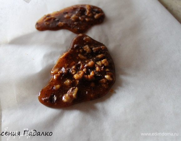 Приготовим грильяж. Для этого кладем сахар в сковороду и поставим на медленный огонь. Как только он растает, добавим перец чили и грецкие орехи.  Слегка перемешаем деревянной ложкой и выльем на пергамент.