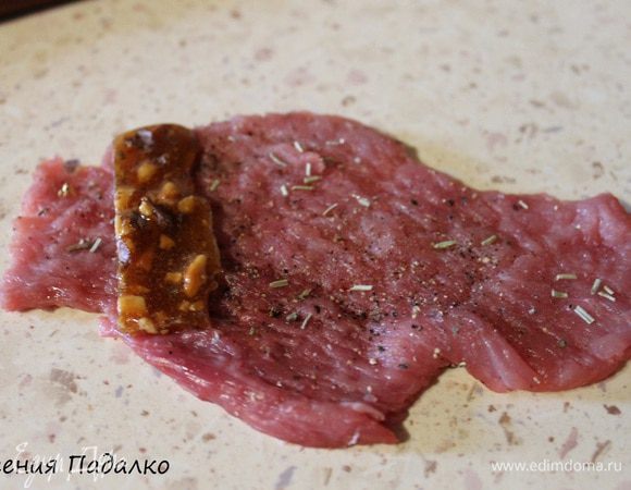 Из голени индейки вырезаем кость, мякоть нарезаем пластинами. Отбиваем с двух сторон. Можно посыпать любимыми травками. На краешек отбивной кладем кусочек грильяжа.