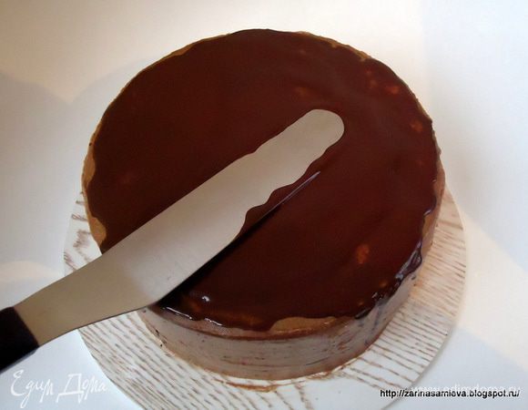 Шоколад растопить с двумя столовыми ложками растительного масла, немного остудить и нанести на верхний корж торта.