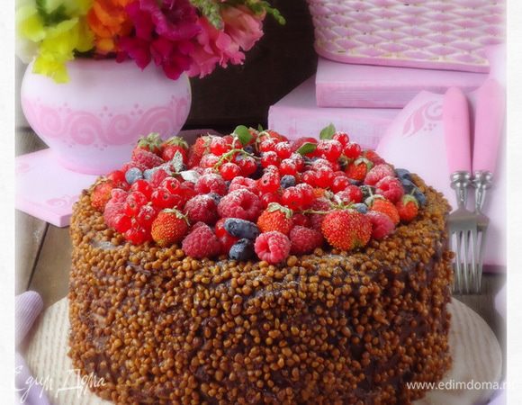 Бока торта обмазать кремом и обсыпать грецким орехом в карамели. Сверху уложить ягодное ассорти.