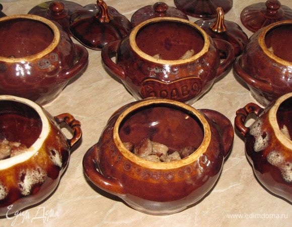 Готовое мясо выложить в горшочки.