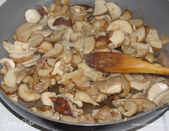 Грибы нарезать пластинками не слишком мелко и обжарить на растительном масле минут 5. В конце жарки добавить мелкорубленный чеснок, посолить. Грибы  выложить в горшочки сверху на мясо.