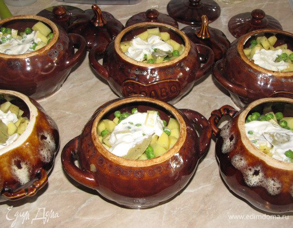 Добавить мясной бульон по вкусу. Если хотите жаркое пожиже, то добавьте бульона побольше, примерно до половины горшочка. Вместо бульона можно взять воду. Сверху положите 1 ст. л. сметаны и лавровый лист. Запекайте в духовке 200 град около 30 минут, до готовности картофеля.