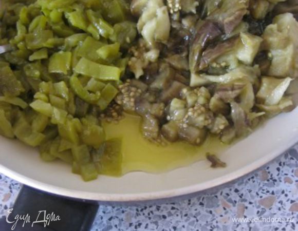 Овощи очистить от кожицы, перцы от семян.
Мелко нарезать.
В скороводе смешать перец, баклажан и оливковое масло.
Готовить на среднем огне, около пяти минут.