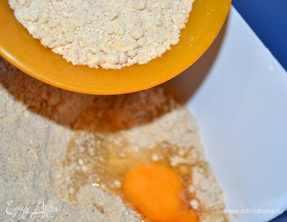 Немного крошки отложить для посыпки верха пирога, но можно и не посыпать крошкой, а использовать миндальные лепестки, например. В тесто добавить яйцо. Перемешать до однородности.