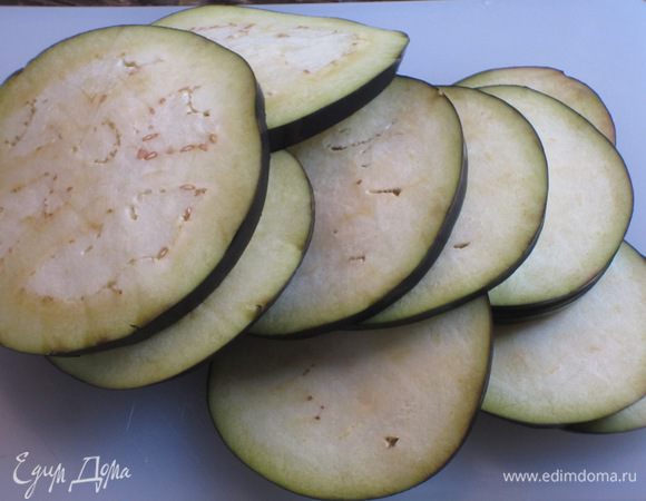 Баклажаны нарезать тонкими кружочками,сбрызнуть оливковым маслом и запечь в разогретой до 220 °С духовке под грилем 3 минуты. Посолить по вкусу.