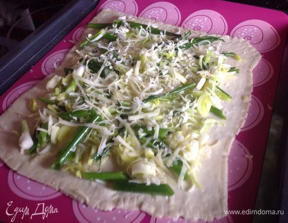 Распределите начинку на тесто, оставляя по краям 2 см. Присыпьте оставшимся тертым сыром.